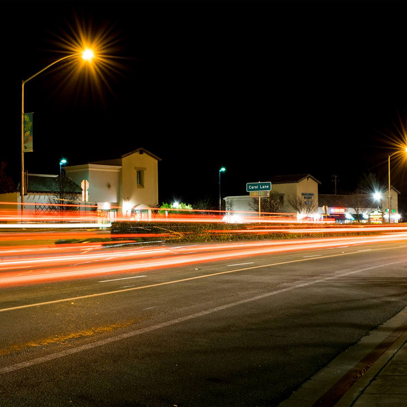 Long exposure light trails along a city street at night.
